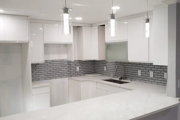 Open-plan kitchen cabinet install with marble flooring and pendant lighting — South Blue Enterprises project in South Florida