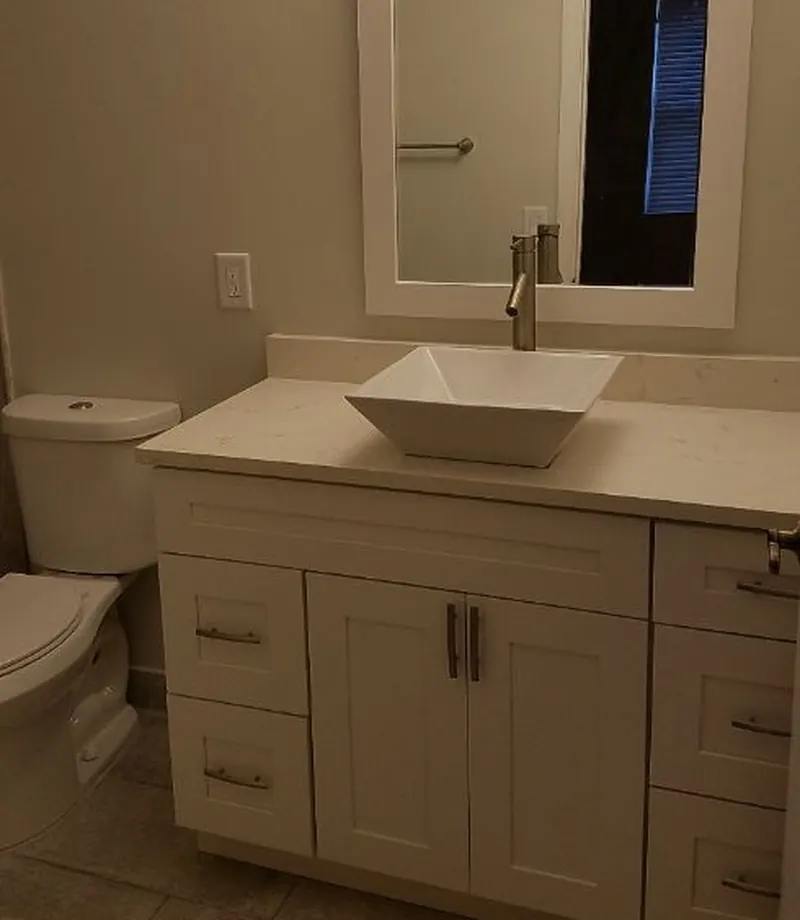 Bathroom with quartz vanity, vessel sink, framed mirror and tile floor — South Blue Enterprises bath repair in Deerfield Beach, FL