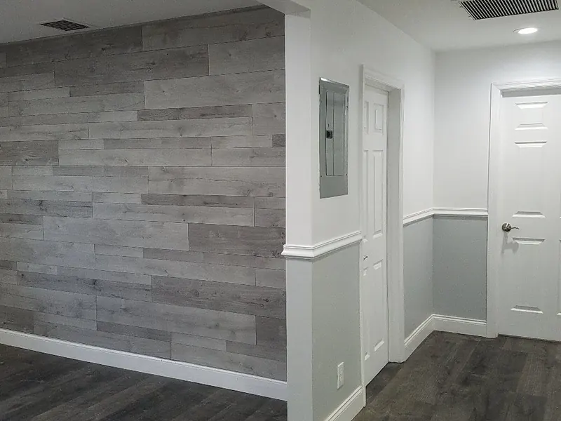 Hallway with two-tone paint, chair rail molding and wood-look accent wall — interior painting by South Blue Enterprises in South Florida